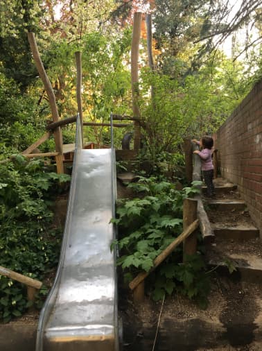 Im Garten haben wir viele Bäume und Pflanzen, eine Rutsche und einen Schaukel sowie ein Spielhaus 